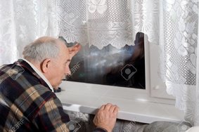 22650719-senior-mann-schaut-durch-ein-fenster-in-der-nacht-als-er-uhren-für-jemanden-zu-erreic...jpg